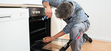 appliance repair in ottawa man repairing oven